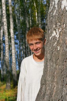 boy stand near the brich in autumn forest