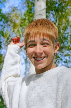 happy boy stand near the brich in autumn forest