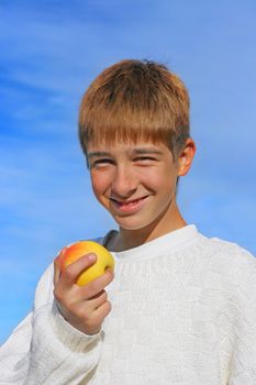 isolated on the blue sky teenage boy with the apple