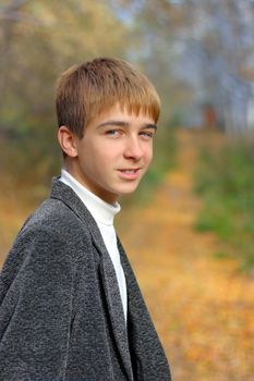 boy in autumn park stand on the road