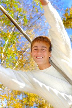 Young and happy teenager jumping in the autumn forest