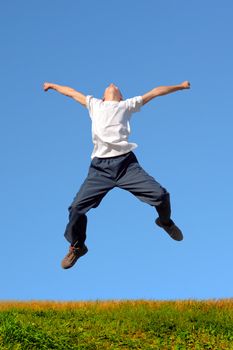 Happy and winning boy jumping on the blue sky background