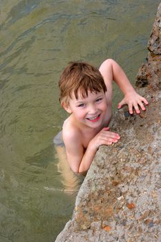 Happy little boy playing in the water