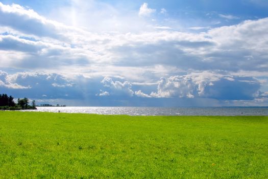 Seaside landscape with green fields and cloudscape