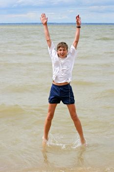 happy teenager jumping in the water