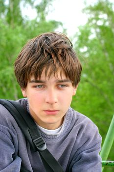 sad teenager sitting on the trees background