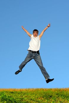 Happy teenager jumping on the blue sky background