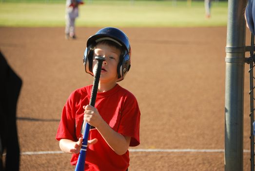 Little league baseball boy staring at end of bat.