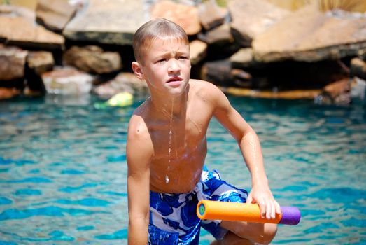 Young boy dripping wet getting out of swimming pool