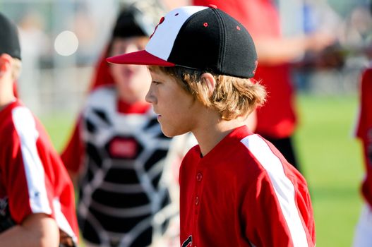 Young baseball player walking back to dugout.