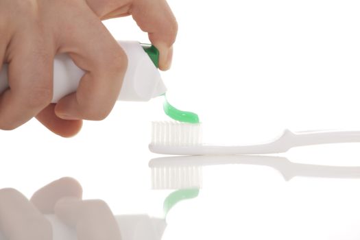 Squeezing toothpaste onto toothbrush