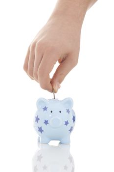 Savings - Piggy bank and hand with coin