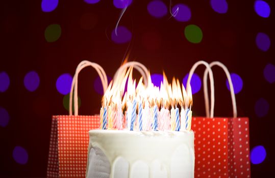 happy birthday cake shot on a red blurred background with candles