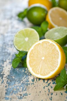 Lemons and limes with fresh mint on table background. Copy space