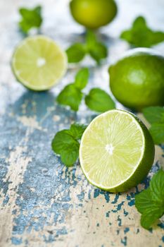 Limes with mint on wooden table background. Macro shot