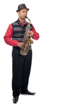 A young man plays his saxophone whilst standing upright.