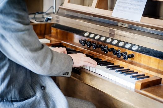 Man playing an old pipe organ in the church