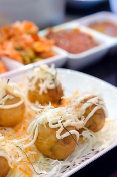 close up octopus balls and vegetable on white plate , Takoyaki japanese food