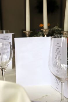 Close-up from an elegant stylish restaurant with menu, empty glasses and decorative candles