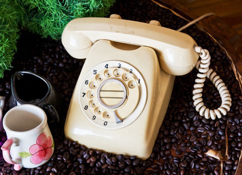 Old phone on the table with coffee beans