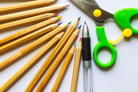 color pencils, pen and scissors on white paper