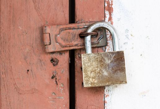 aged door locked by brass padlock