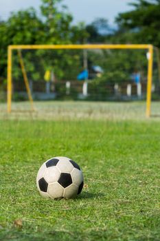 football (soccer) and goal on green field