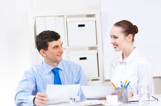 colleagues discuss the reports at a desk in the office, working together in business