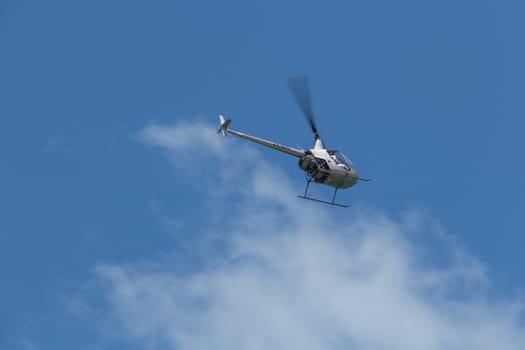 The helicopter in the clouds on a blue sky.