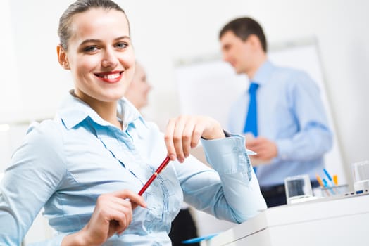 portrait of a business woman in office, smiling and looking into the camera, office work