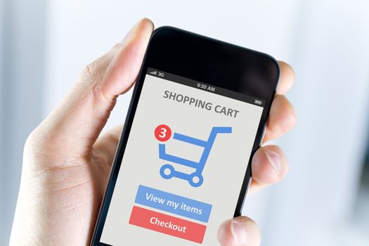 Mens hand holding modern mobile phone with online shopping application on a screen. 