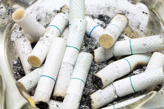 Dozen of Cigarette butt in an ashtray.