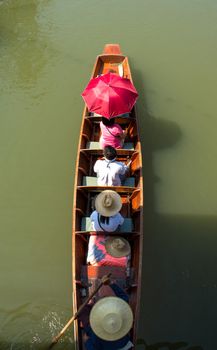 Tourists sailing on traditional thai long tail boat at Amphawa floating market Thailand