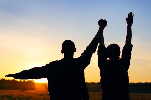 Friends silhouette on sunset background