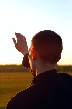 young man silhouette on sunset background