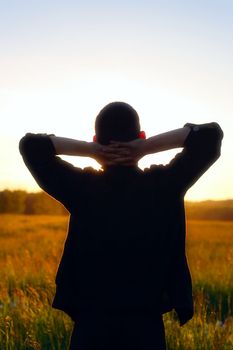 young man silhouette on sunset background