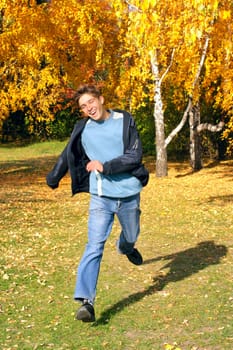 happy teenager running in the autumn park