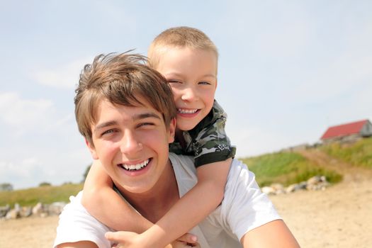 happy teenager and kid on the beach