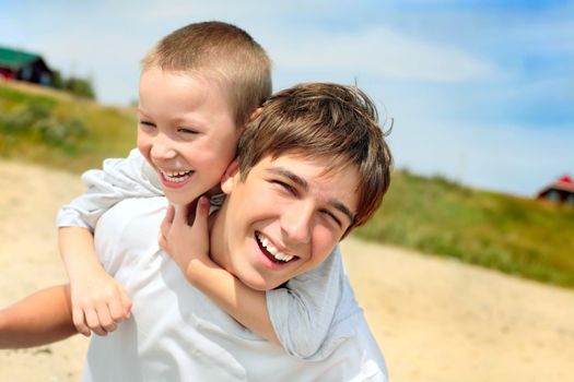 happy teenager and kid on the beach