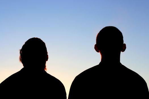 Two Friends silhouette on evening sky background