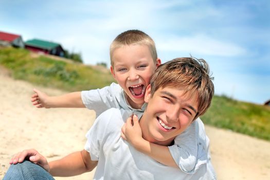 happy teenager and kid on the beach