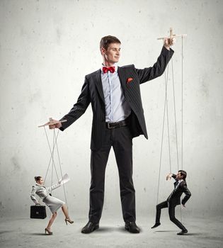 Image of young businessman puppeteer. Leadership concept