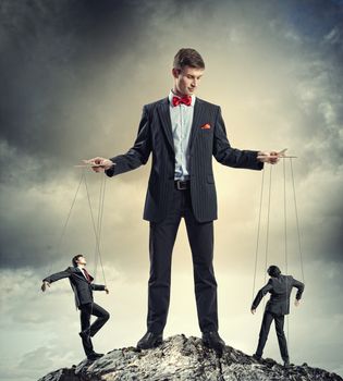 Image of young businessman puppeteer. Leadership concept