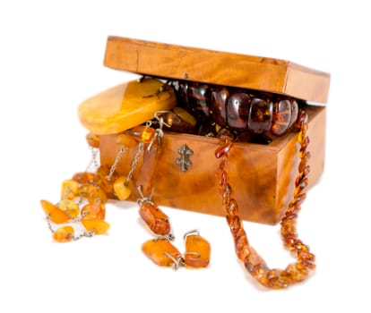 amber stone apparel jewelry in vintage wooden box chest isolated on white.
