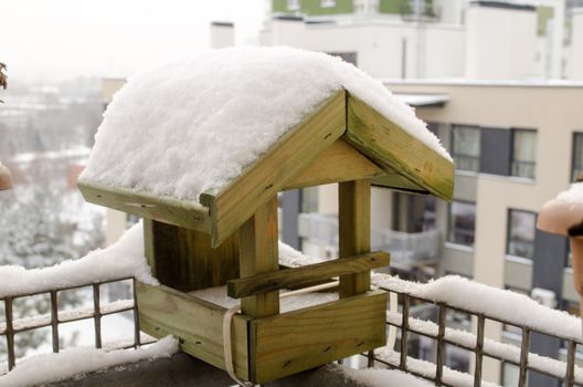 wooden small house birdie abundant snow covered roof on the balcony edge in cold winter time