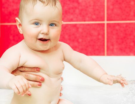 cute smiling baby in bath in mothers hands