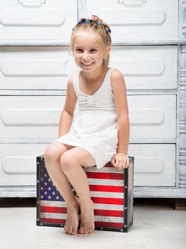 little girl with a suitcase in colors of American flag