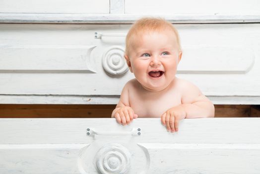 Cute smiling little baby in a drawer