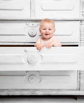Smiling little baby in a drawer