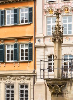 Old pillory post above fountain at Schwabisch Hall, Germany. Dating from 1509, the fountain stands against a decorative wall adorned with statues of Samson, St Michael and St George. The rectangular design is unusual in a Gothic fountain.